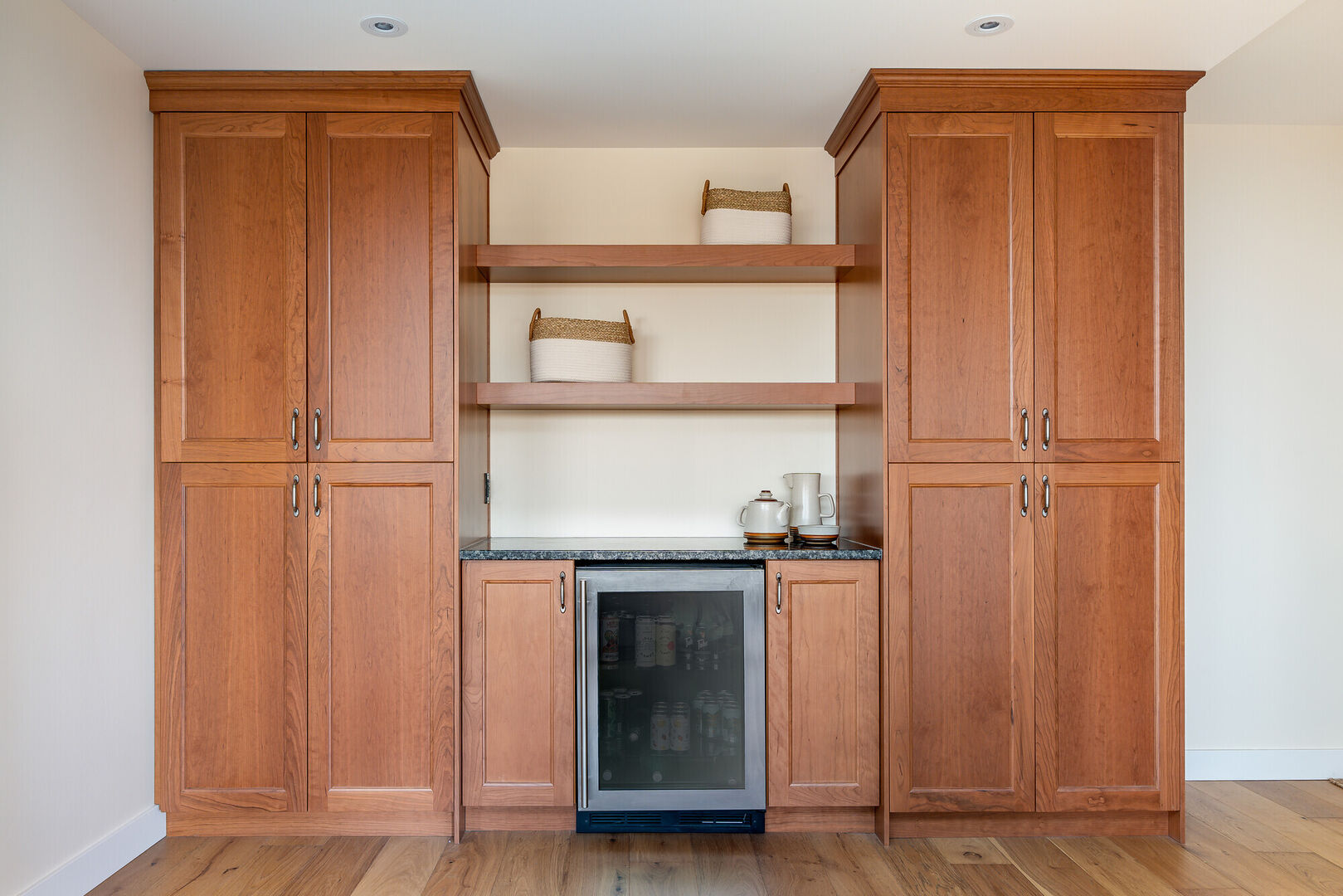 Custom wood dry bar design with mini fridge